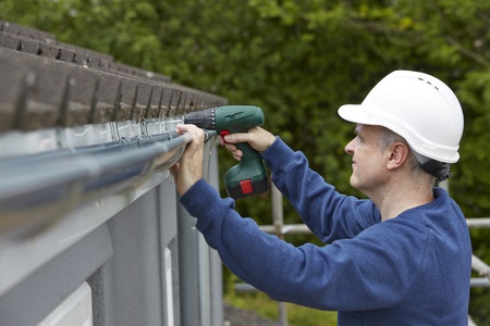 Repairman Working on Gutters at a Home